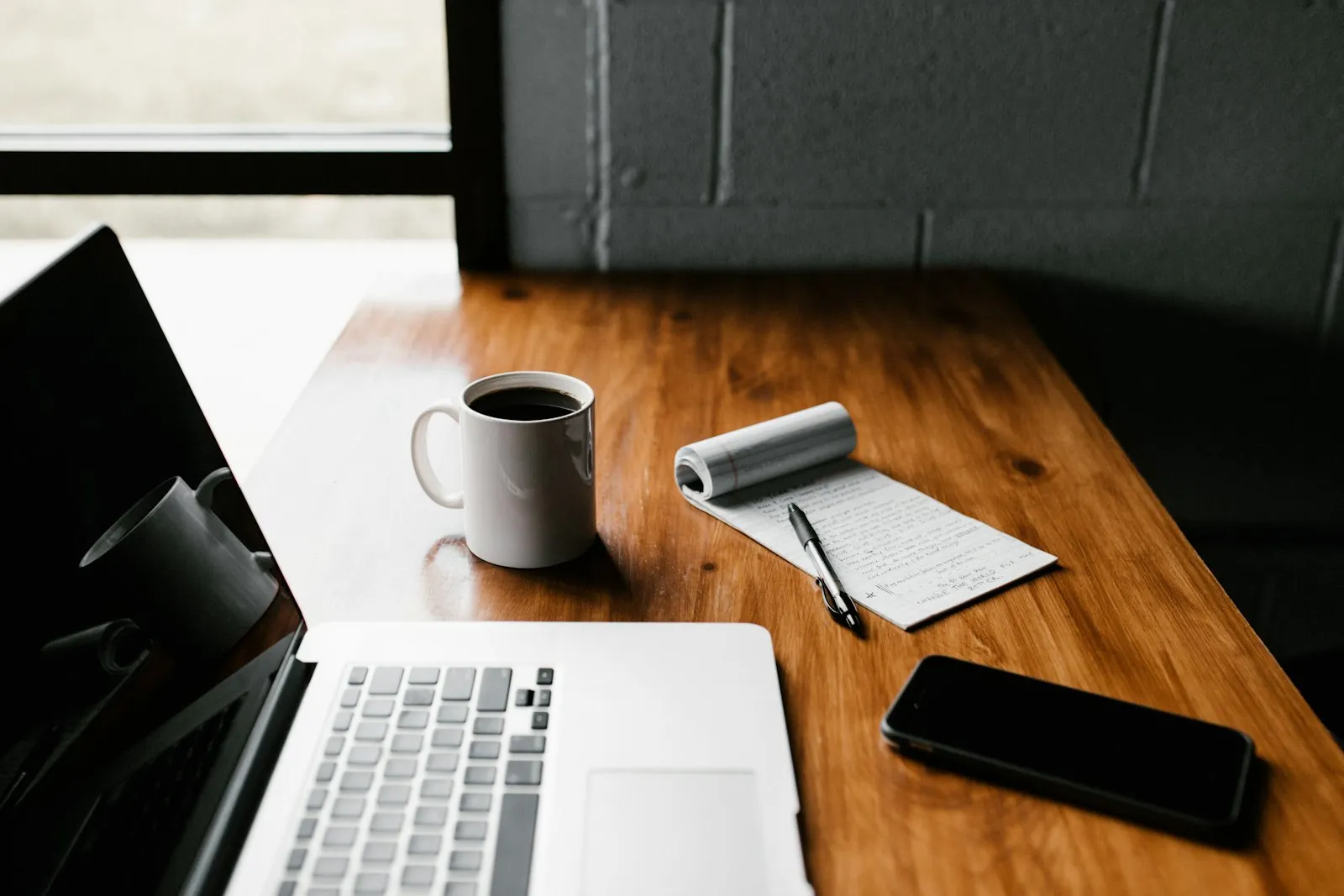 A phone and a laptop side by side on a desk